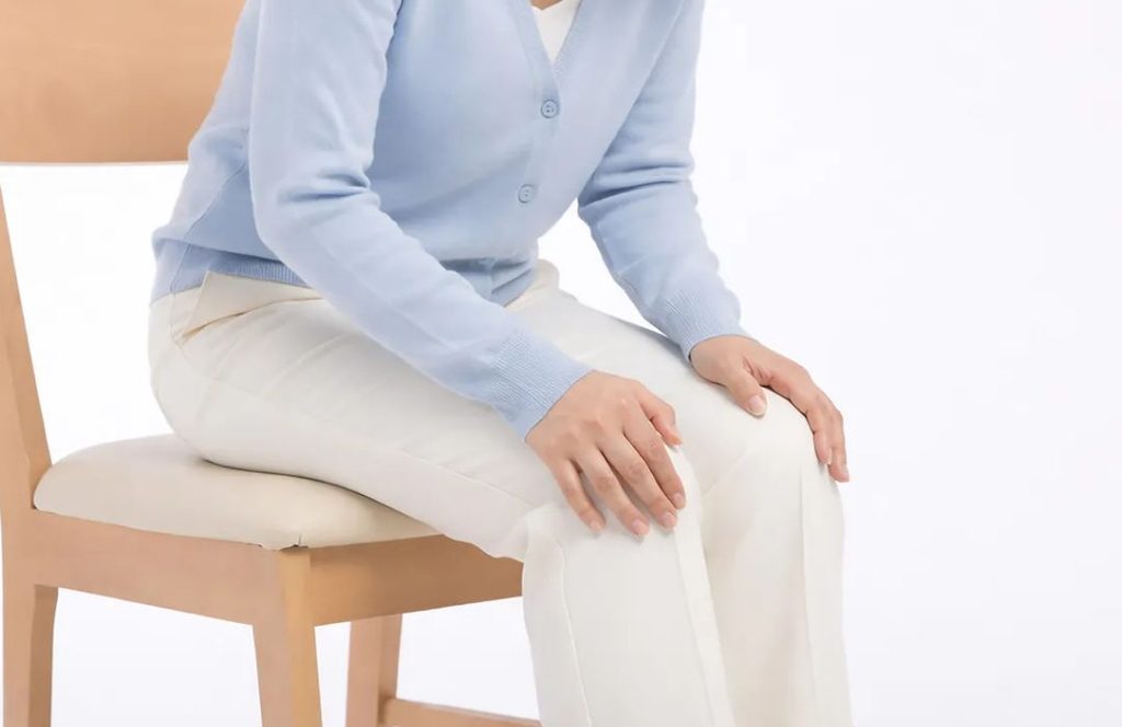 무릎 관절음과 함께 통증이나 붓기 같은 증상이 있는지 살펴보는 상황을 표현한 이미지